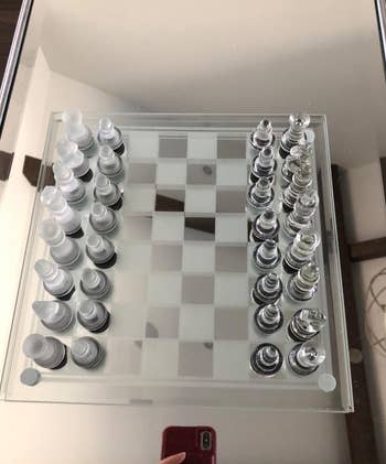 Glass chess set on a mirrored board