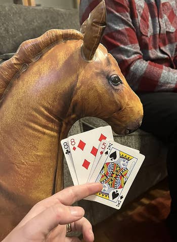 A reviewer dealing the blow up horse into a card game 