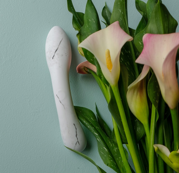 Faux marble porcelain dildo next to flowers