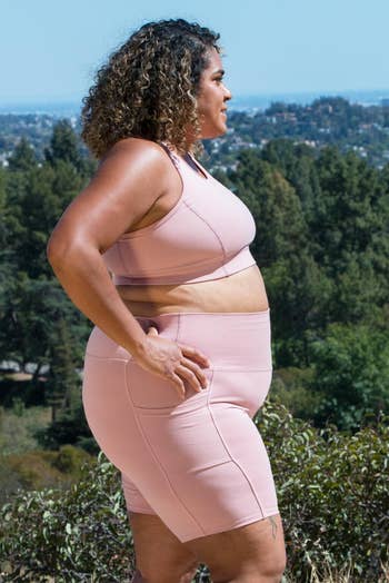 Plus-size idiosyncratic   wearing a matching diversion  apical  and motorcycle  shorts stands successful  a quality  setting, looking into the distance
