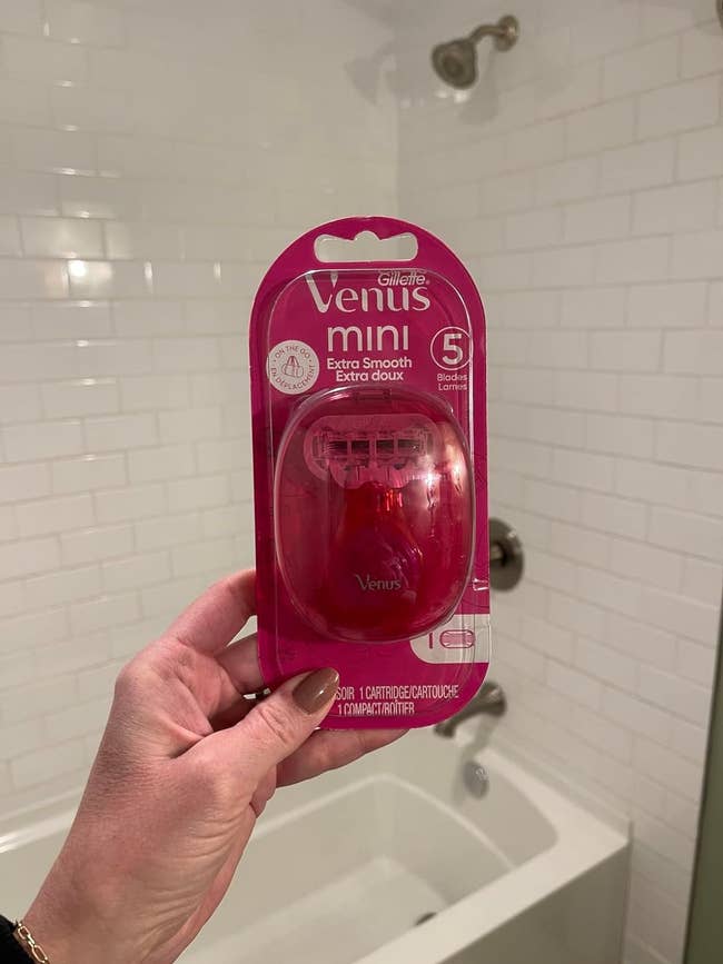 Hand holding a Gillette Venus Mini Extra Smooth razor in packaging