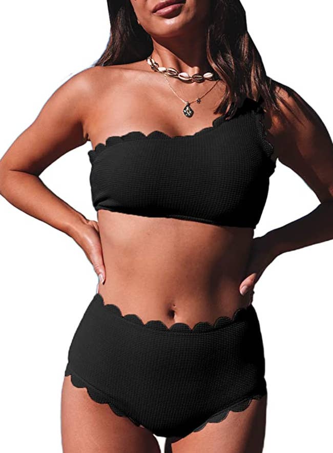 model wearing one shoulder scalloped bikini in black