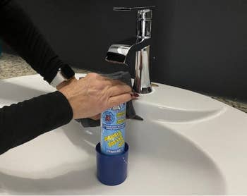 hands using it on a sink without the handle