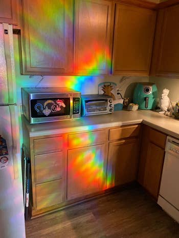 rainbows from the window film cast across a kitchen