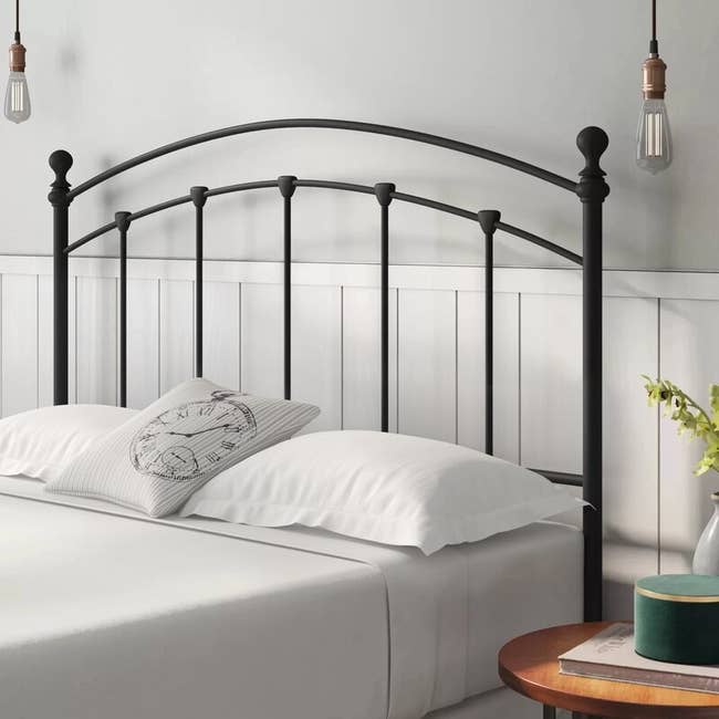 A black and open headboard on a white bed