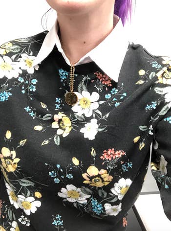 Closeup of reviewer wearing the collar with a floral shirt 