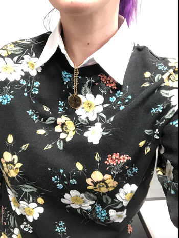 Closeup of reviewer wearing the collar with a floral shirt 