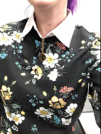 Close-up of reviewer wearing the collar with a floral shirt 