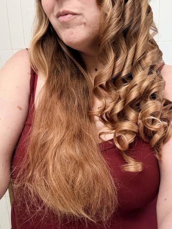 reviewer with fractional  straight, fractional  curled hair, wearing a sleeveless top