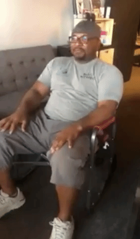 Video of reviewer rocking in foldable outdoor rocking chair in gray shirt, dark gray shorts, and white sneakers