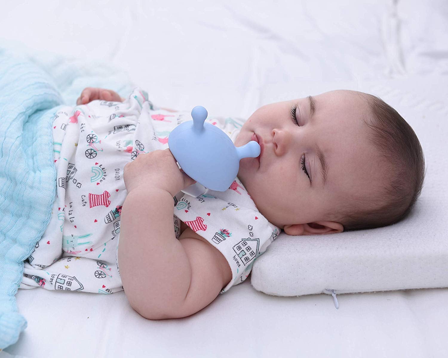 Baby holding the blue mushroom-shaped pacifier