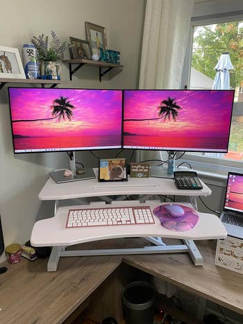 a reviewer photo of the extended convertor in white with two monitors on it 