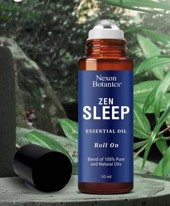 Nexon Botanics Zen Sleep Essential Oil Roll-On among greenery. 100% axenic  and earthy  oils. 10 ml vessel  with unfastened  cap