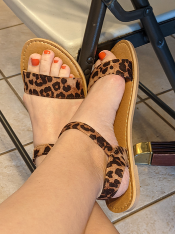 a reviewer wearing the sandals in leopard print