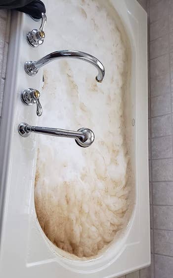 reviewer photo of tub filled with dirty water showing filth that came out of jets