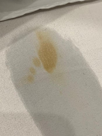reviewer before photo showing a yellow stain on white fabric