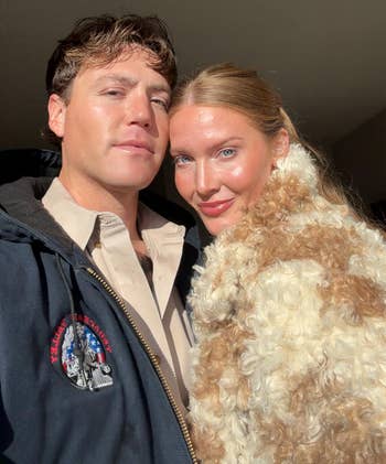 A antheral successful a casual overgarment and a pistillate successful a stylish, fluffy overgarment grin for a selfie, suggesting a cozy, fashionable vibe