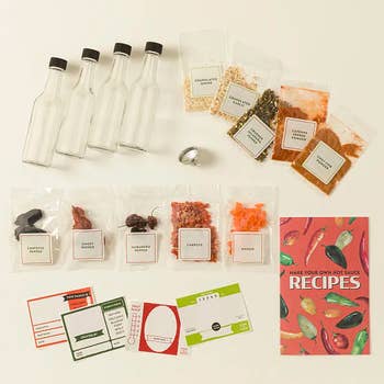 Hot condiment making kit with bare bottles, spices, and an acquisition booklet titled