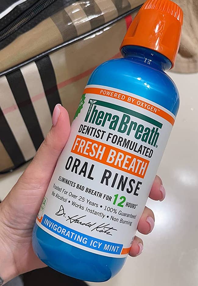 Hand holding the large bottle of oral rinse 