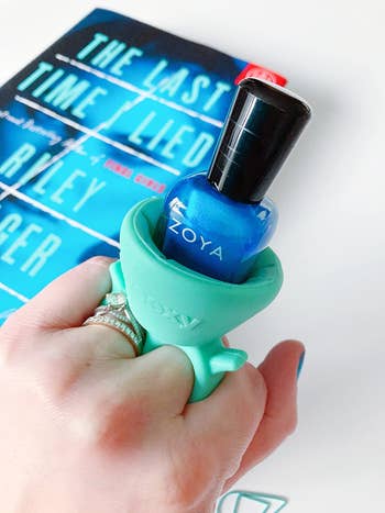 Reviewer image with the mint green grip on their finger with nail polish in it