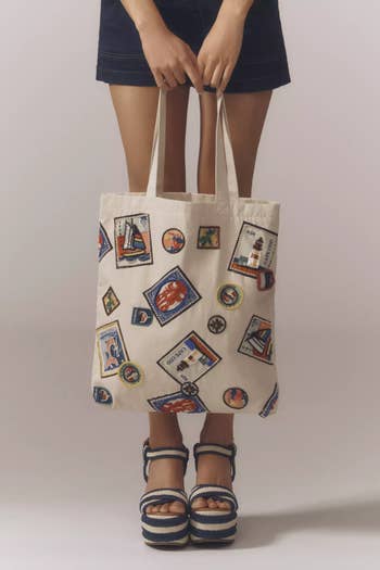 Person holding a tote container  with travel-themed patches