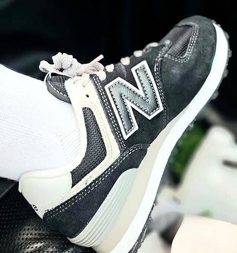 Close-up of a ft  wearing a New Balance sneaker with classical  styling, paired with a achromatic  sock, featured successful  a buying  article