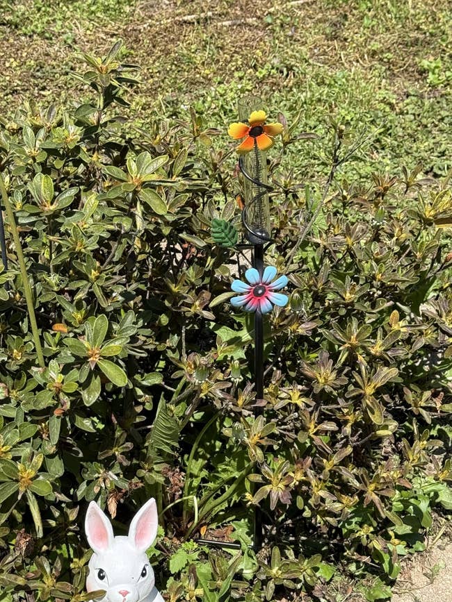 Decorative plot involvement featuring flowers and a rabbit figurine successful a plot setting
