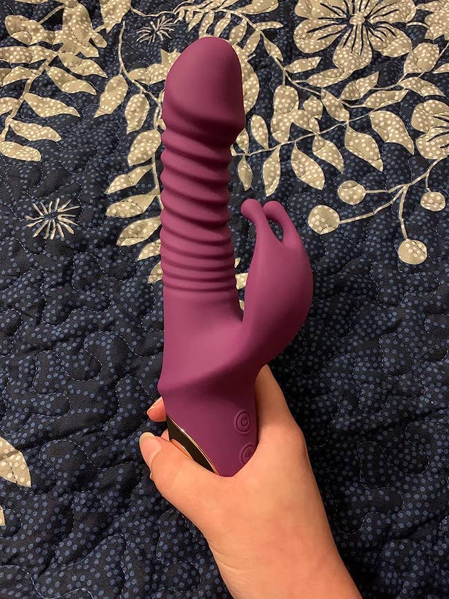 Reviewer holding purple thrusting rabbit vibrator