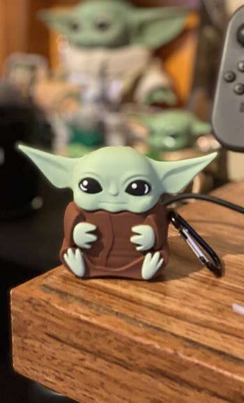 Reviewer's case shaped like baby yoda's full body with carabiner clip