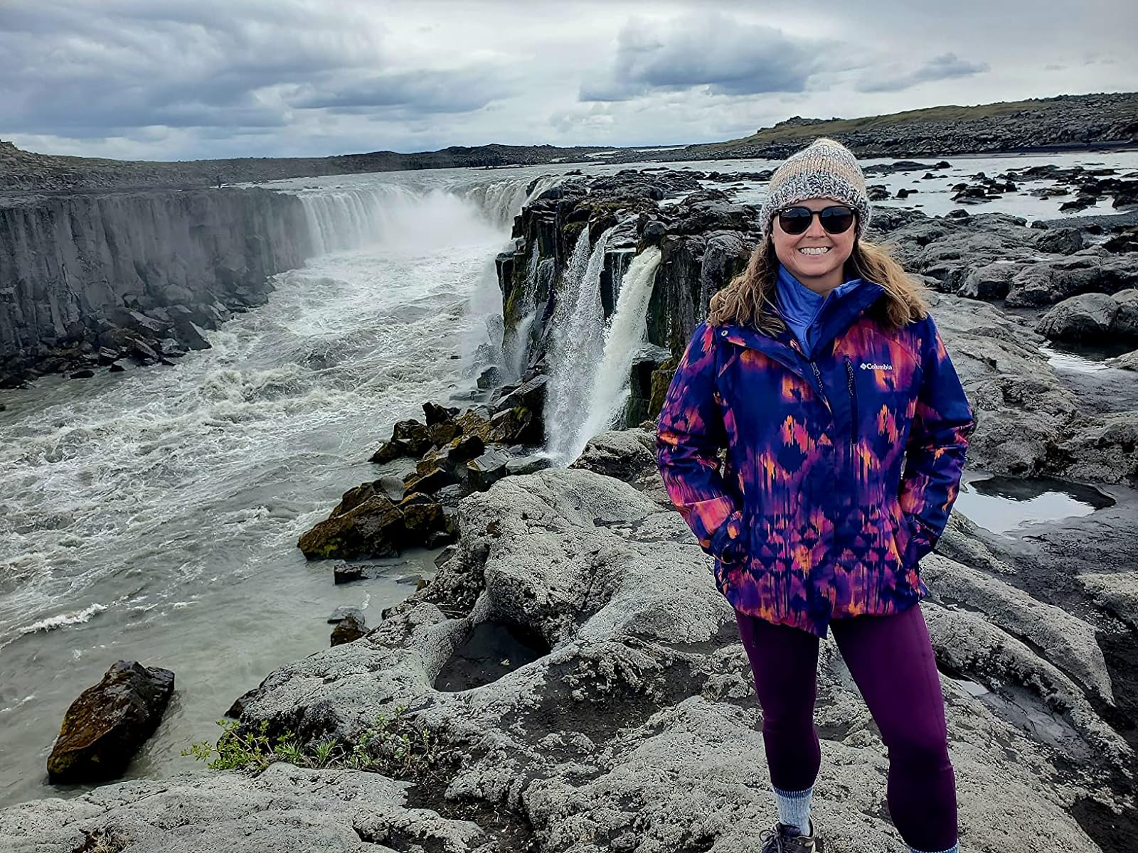 a reviewer successful  beforehand   of a waterfall wearing the purple leggings