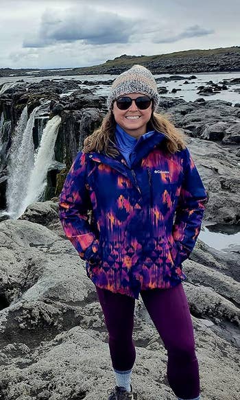 a reviewer successful beforehand of a waterfall wearing the purple leggings