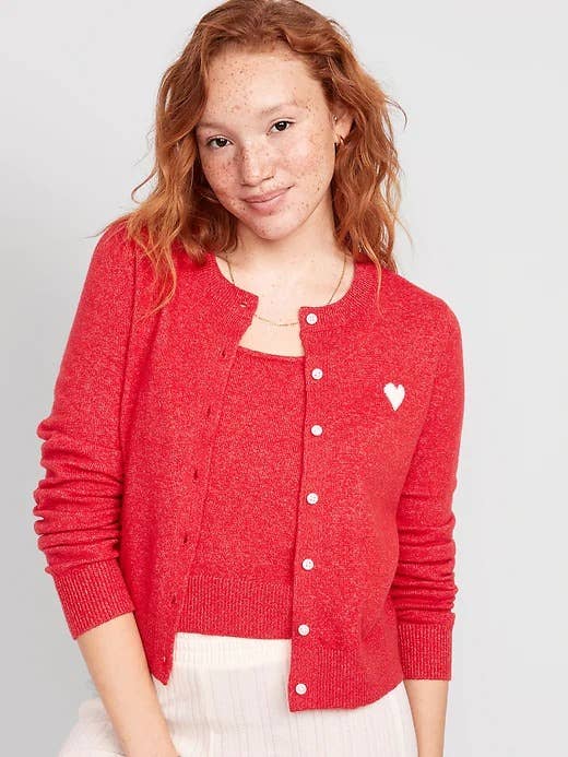 model wearing the red sweater with a heart on it 