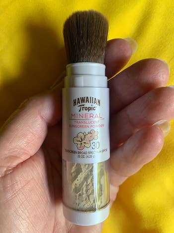 Hand holding Hawaiian Tropic Mineral Translucent Sunscreen Powder SPF 30