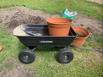 The dump cart with a pot, dirt, and a small shovel inside if it 