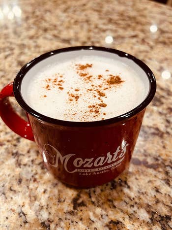 a reviewer photo of a mug filled with a drink topped with frothed milk 