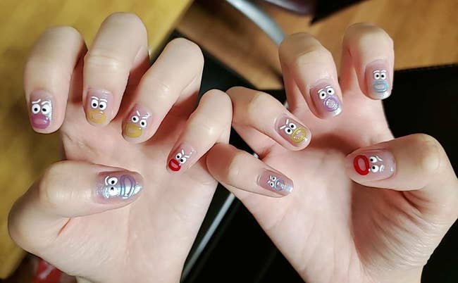 Hands with Muppet-themed nail art, each   featuring antithetic  quality  faces with expressive eyes and mouths