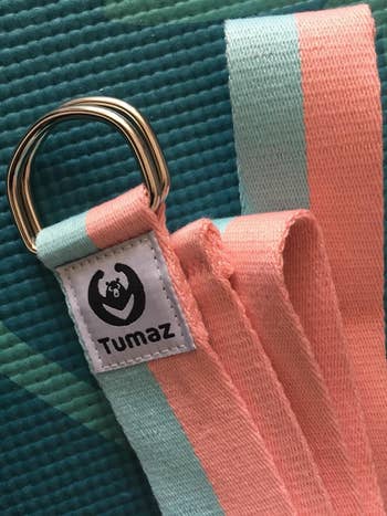 Yoga strap with a metallic  D-ring buckle, labeled 