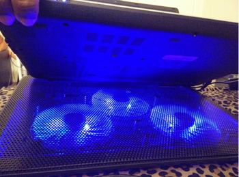 The flat cooling pad with three fans that have a blue glow 