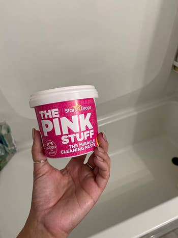 reviewer holding up the pink stuff tub