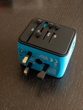 reviewer image of the blue universal adapter on a table