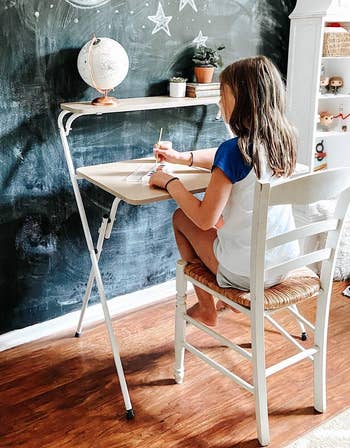 the two tier folding desk with a kid painting at it