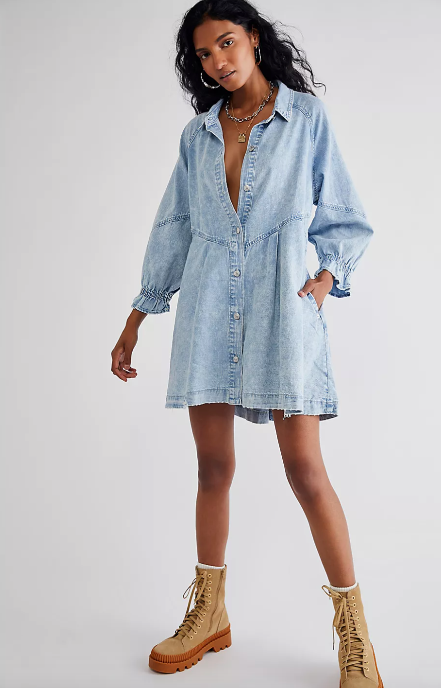 a model in a light wash denim dress paired with work boots