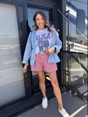 Woman successful  a casual denim jacket, graphic tee, and checkered shorts, lasting  outdoors