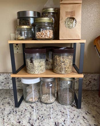 reviewer's two black and natural shelves on a counter holding herbs and nuts