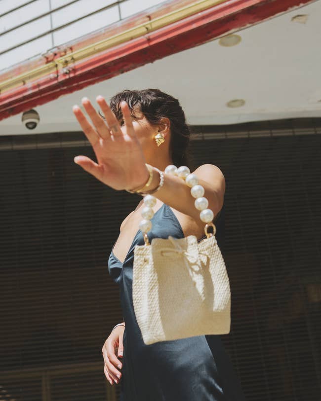a model holding the natural colored purse