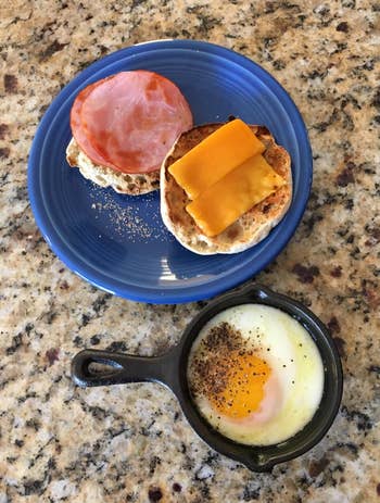 reviewer cooking an egg for an english muffin sandwich in the skillet 