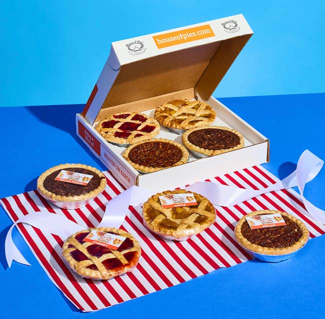 Assorted mini pies displayed with decorative ribbons, featuring lattice crust and effect fillings, successful beforehand of an unfastened container labeled