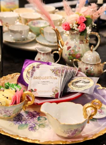 Elegant tea set with 'Bridgerton' themed packaging on a tray, suggesting products for fans of the show