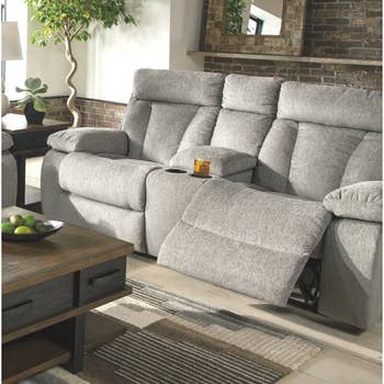 lifestyle photo of gray reclining couch with footrest up