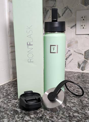 mint green bottle showing three different kinds of lids